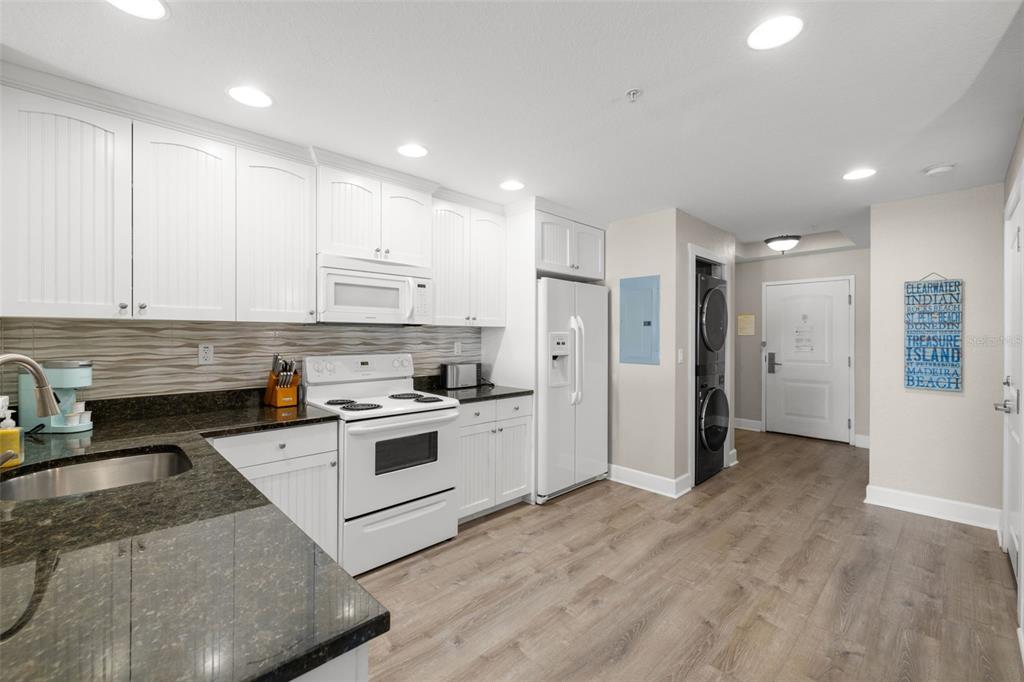 399 2nd Street, Unit 216 Indian Rocks Beach, FL 33785 - Photo 5 of 45 a kitchen with stainless steel appliances granite countertop a refrigerator and a stove top oven