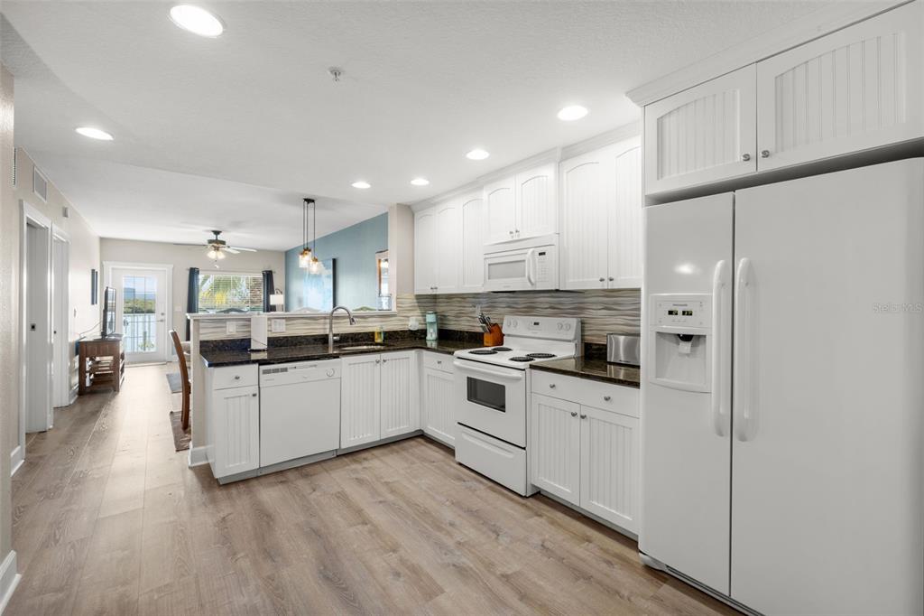 399 2nd Street, Unit 216 Indian Rocks Beach, FL 33785 - Photo 9 of 45 a kitchen with white cabinets and white appliances