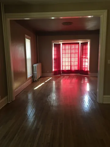 a view of a livingroom with wooden floor and window