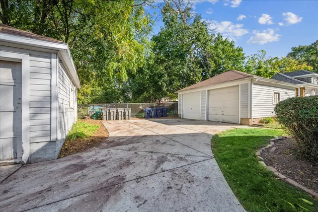 a view of a house with a yard and a large tree