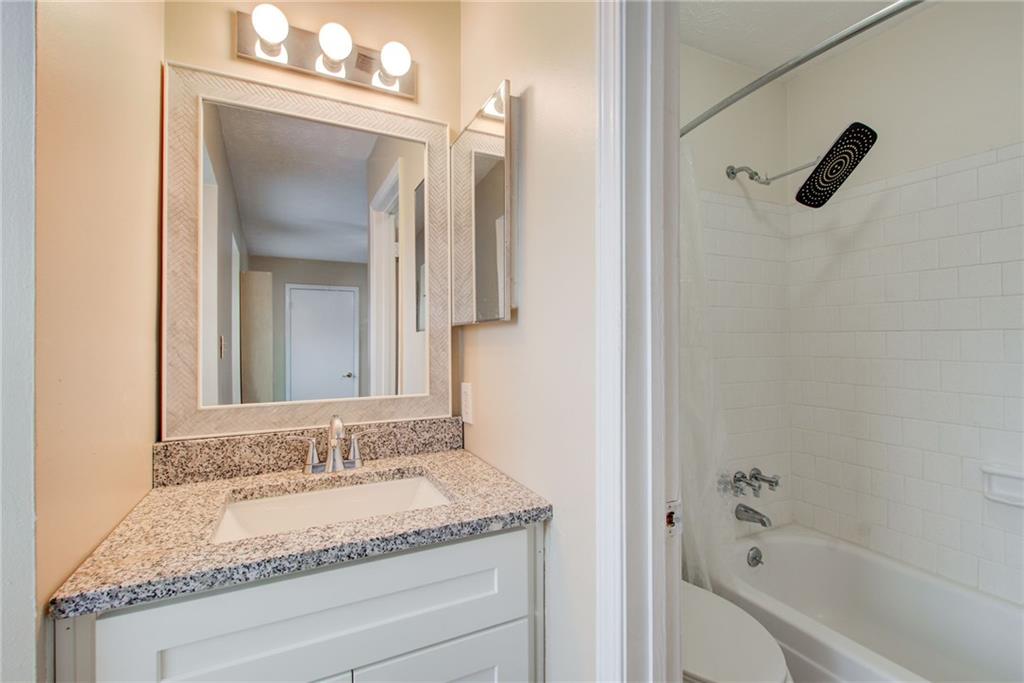 10 Market Square Place Northwest Atlanta, GA 30318 - Photo 29 of 36 a bathroom with a granite countertop sink mirror and a bathtub