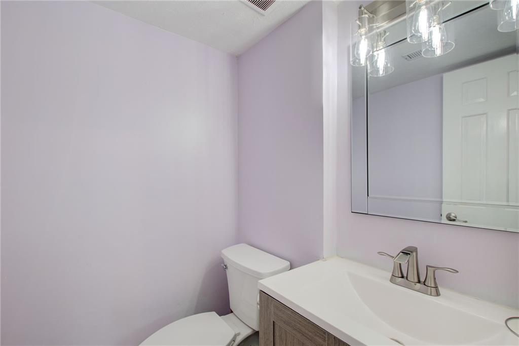 10 Market Square Place Northwest Atlanta, GA 30318 - Photo 5 of 36 a bathroom with a sink a toilet and mirror