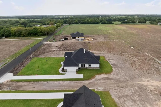 an aerial view of a house with a yard and lake view