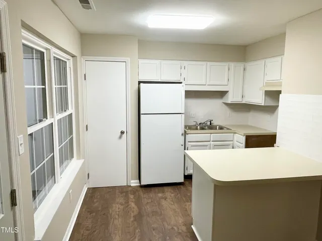 a kitchen with a refrigerator a stove top oven and a refrigerator