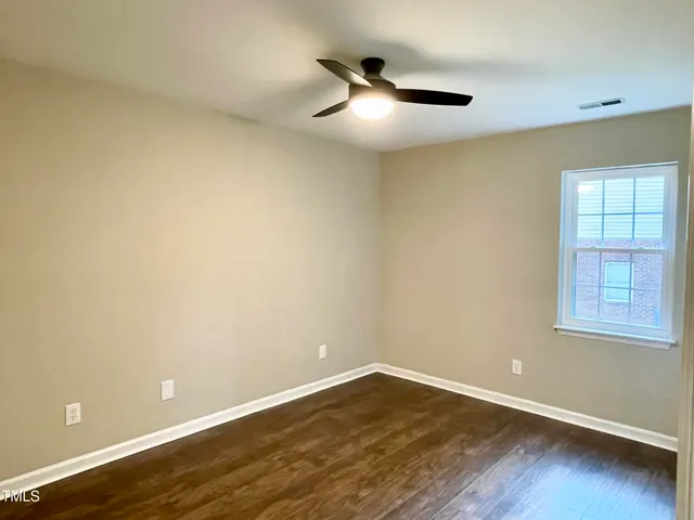an empty room with wooden floor and closet