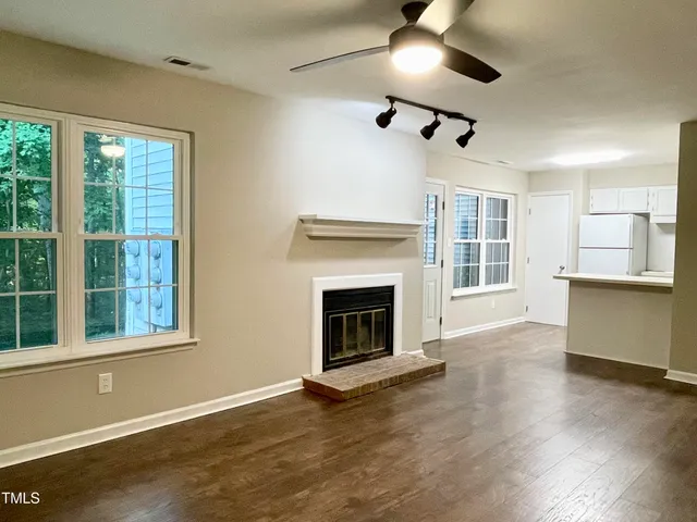 a view of an empty room with a fireplace and a window