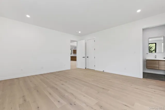 a view of empty room with wooden floor and closet