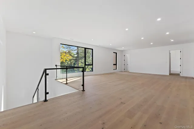 a view of room with wooden floor and white walls