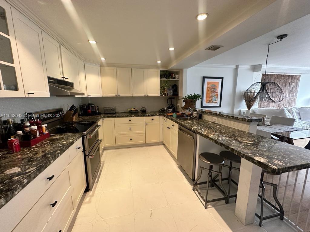 199 Ocean Ln Drive, Unit 613 Key Biscayne, FL 33149 - Photo 5 of 11 a kitchen with granite countertop a sink stove and cabinets