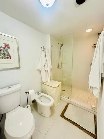a white toilet sitting next to a bath tub shower