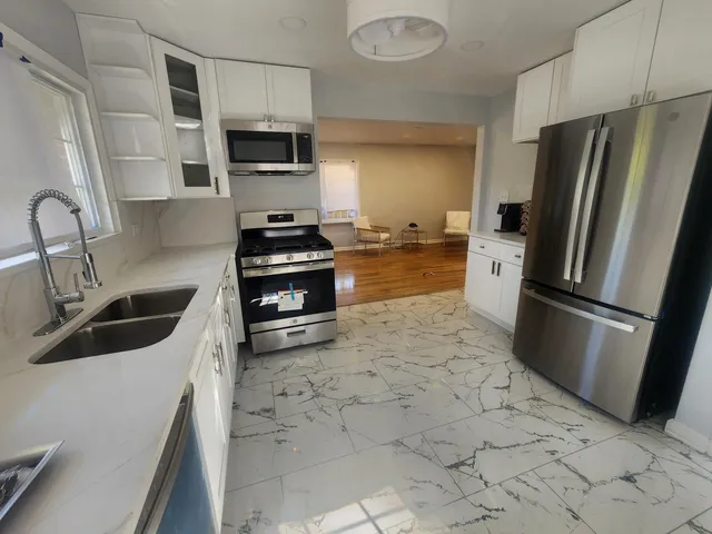a kitchen with stainless steel appliances a refrigerator sink and stove