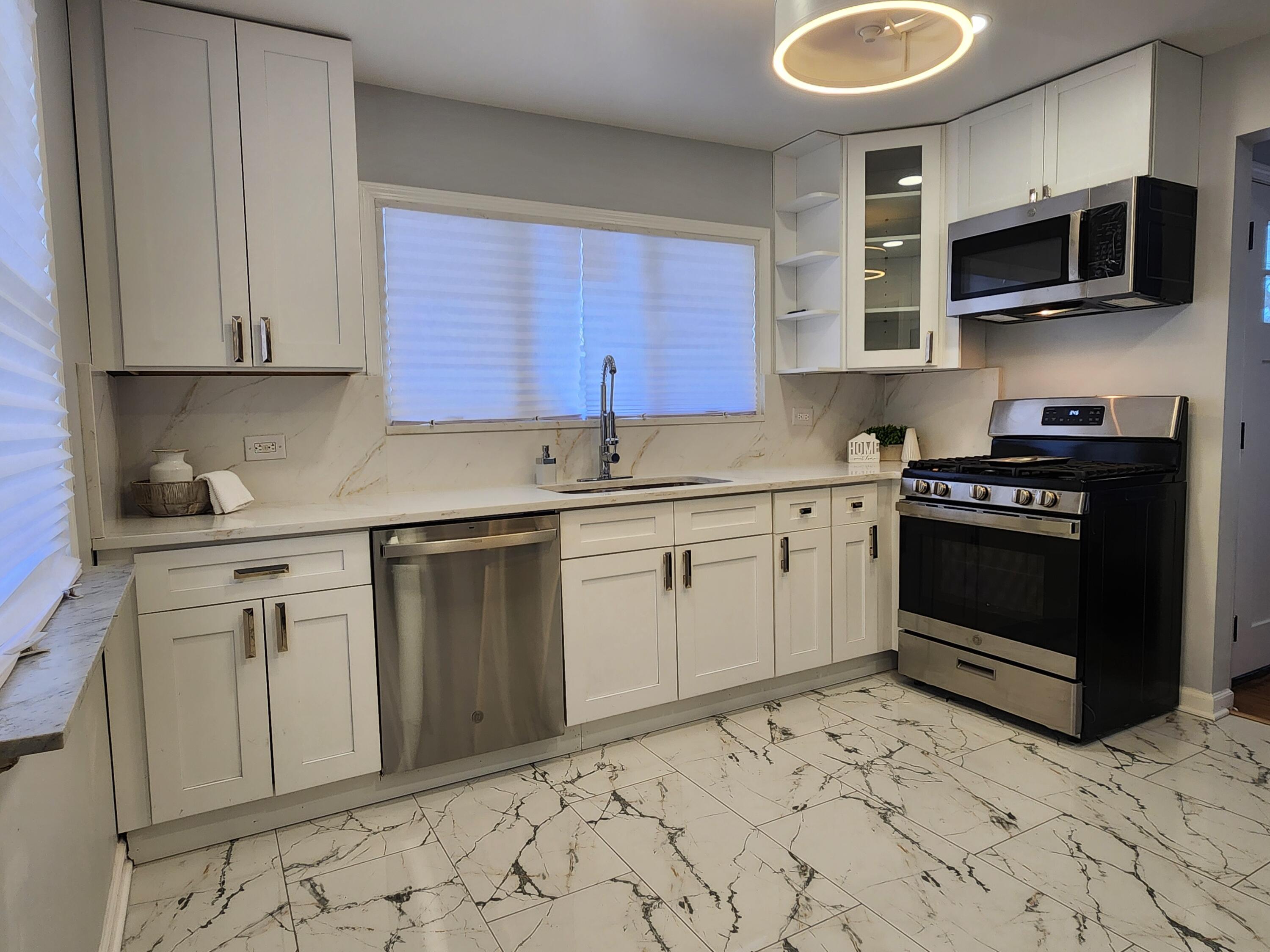 851 Johnson Street Gary, IN 46402 - Photo 5 of 24 a kitchen with stainless steel appliances granite countertop a stove a sink and a microwave