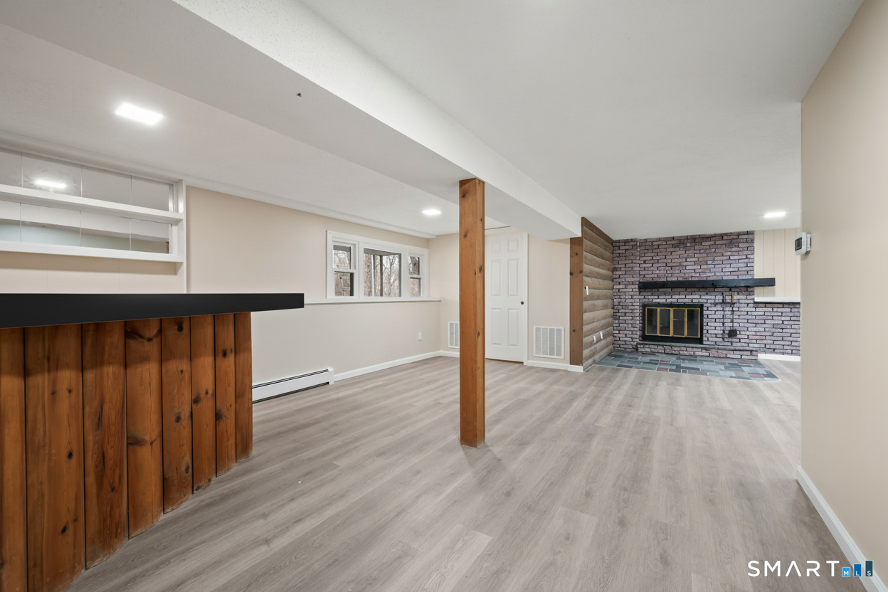 252 Blue Ridge Drive Manchester, CT 06040 - Photo 17 of 40 Large room featuring fireplace with gas log, dry bar and living space. Note brick is more white washed than in photo.