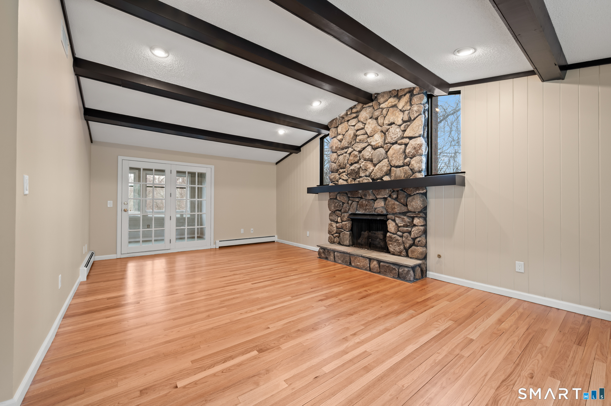 252 Blue Ridge Drive Manchester, CT 06040 - Photo 2 of 40 Open-concept living area with exposed beams and floor-to-ceiling stone fireplace uncommon for raised ranch design.
