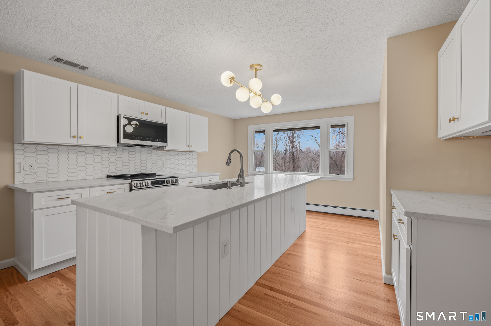252 Blue Ridge Drive Manchester, CT 06040 - Photo 4 of 40 Updated kitchen with quartz countertops, white shaker cabinetry, and center island.