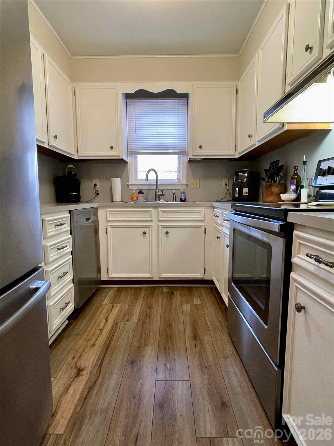 1330 5th Street Northeast, Unit 191 Hickory, NC 28601 - Photo 13 of 37 a kitchen with cabinets wooden floor and stainless steel appliances