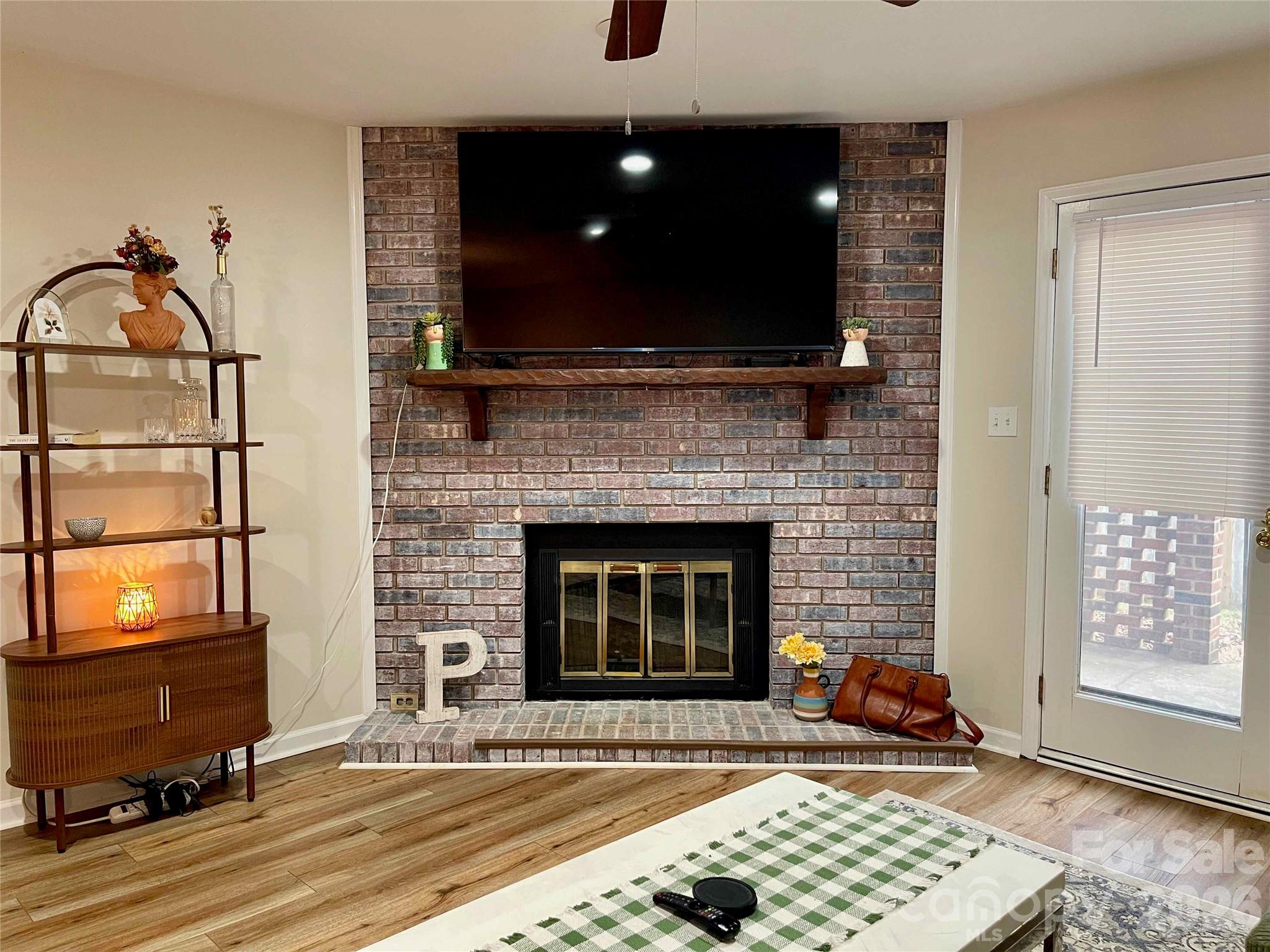 1330 5th Street Northeast, Unit 191 Hickory, NC 28601 - Photo 7 of 37 a living room with a fireplace a flat screen tv and a window