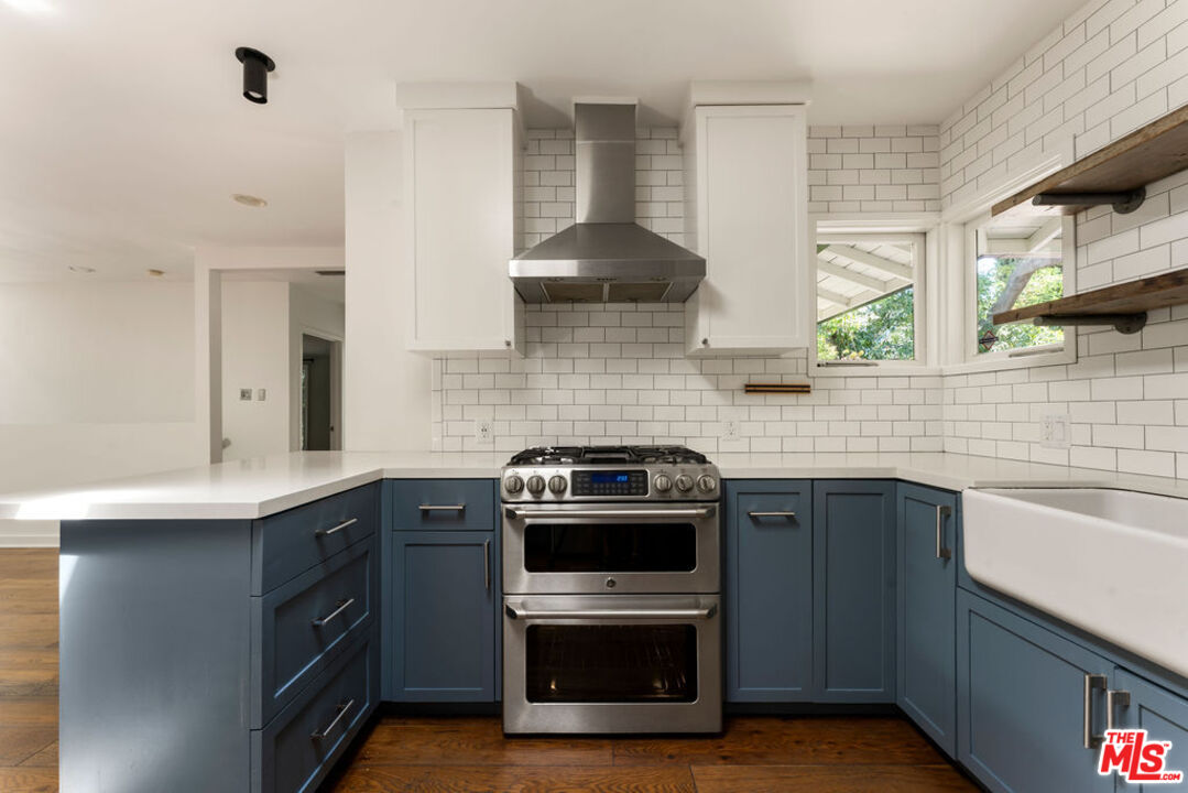 1530 Elevado Street Los Angeles, CA 90026 - Photo 11 of 44 a kitchen with a sink stove and cabinets