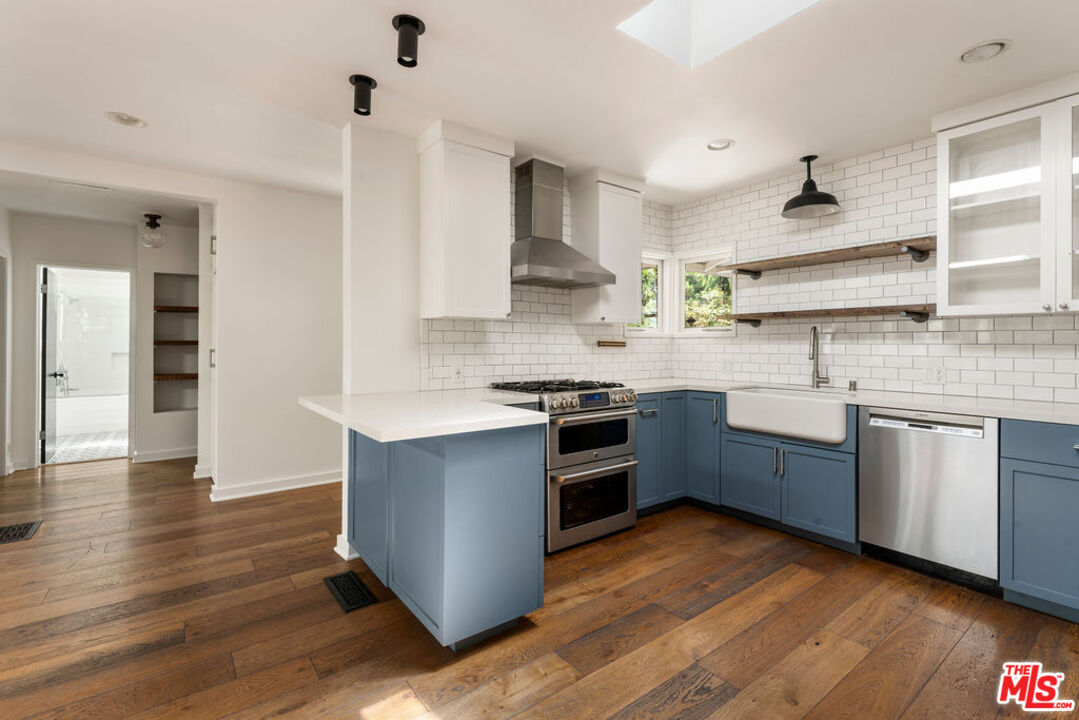 1530 Elevado Street Los Angeles, CA 90026 - Photo 12 of 44 a kitchen with granite countertop a sink cabinets and stainless steel appliances