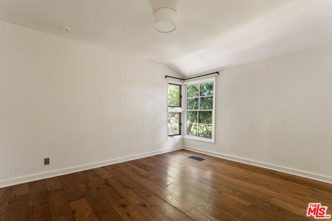 1530 Elevado Street Los Angeles, CA 90026 - Photo 19 of 44 an empty room with wooden floor and windows