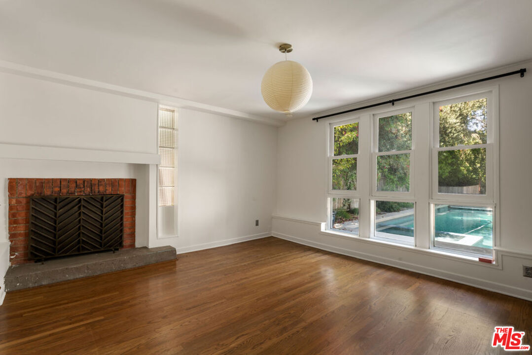 1530 Elevado Street Los Angeles, CA 90026 - Photo 27 of 44 an empty room with wooden floor and fireplace