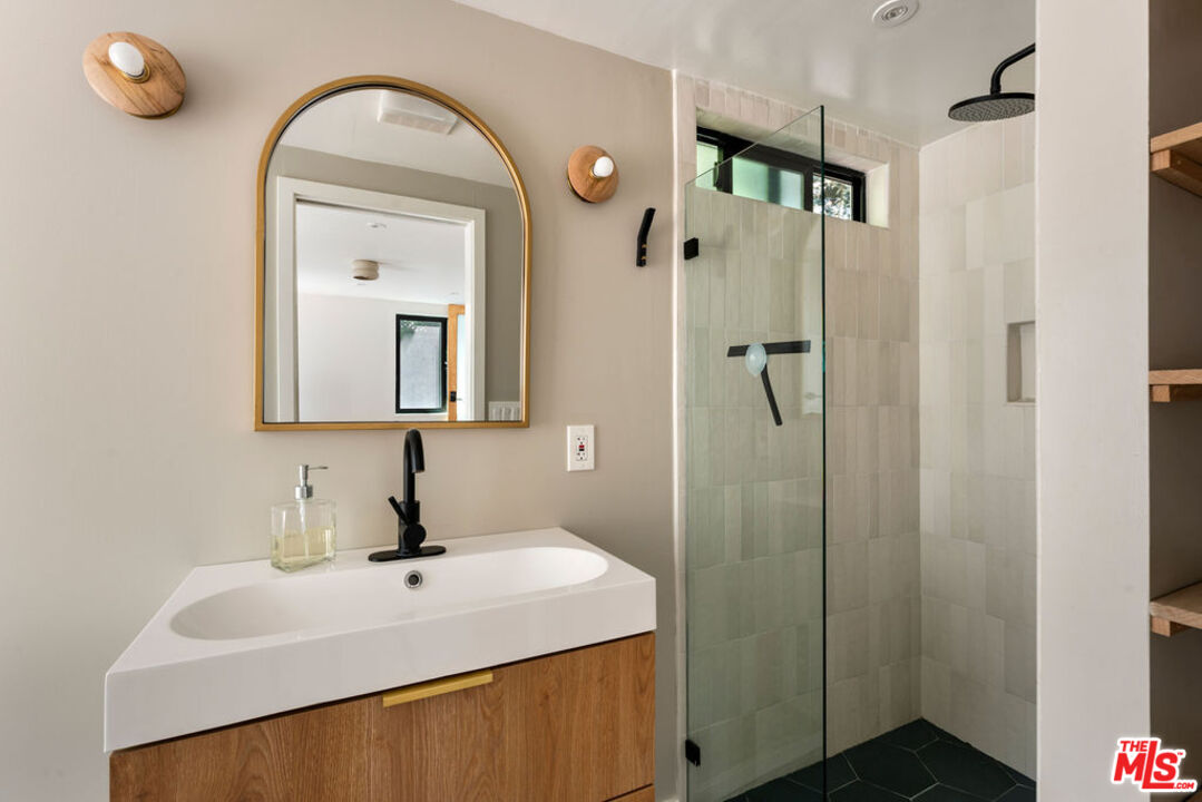 1530 Elevado Street Los Angeles, CA 90026 - Photo 33 of 44 a bathroom with a sink a mirror and shower