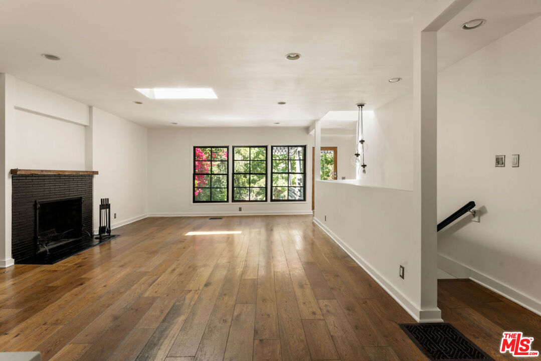 1530 Elevado Street Los Angeles, CA 90026 - Photo 9 of 44 a view of an empty room with wooden floor and a window