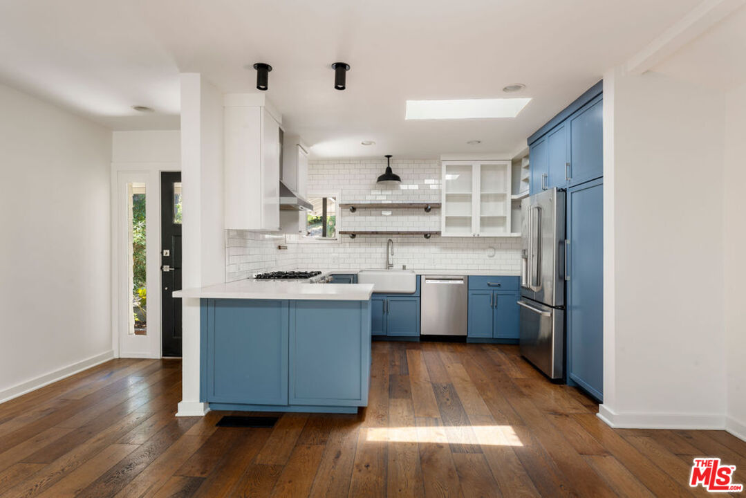 1530 Elevado Street Los Angeles, CA 90026 - Photo 10 of 44 a kitchen with stainless steel appliances a sink cabinets and wooden floor