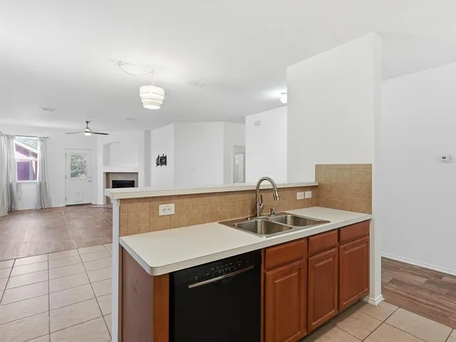 a kitchen with a sink cabinets and wooden floor