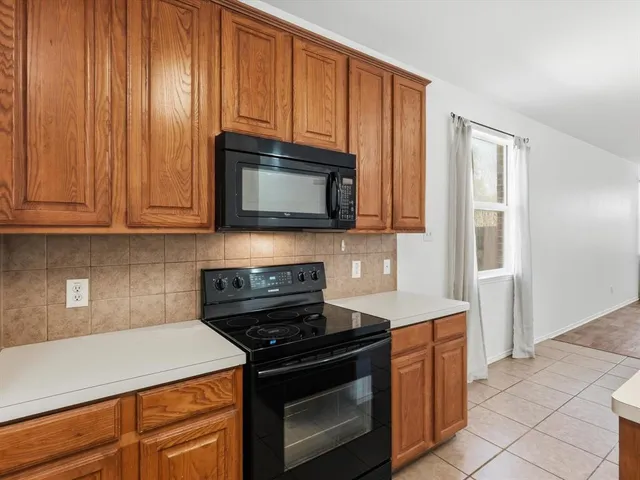 a kitchen with granite countertop a stove top oven cabinetry a sink and dishwasher