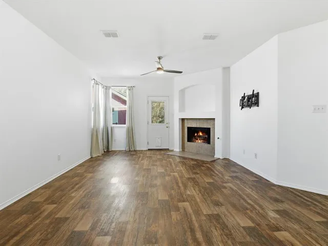 a view of empty room with wooden floor and fireplace