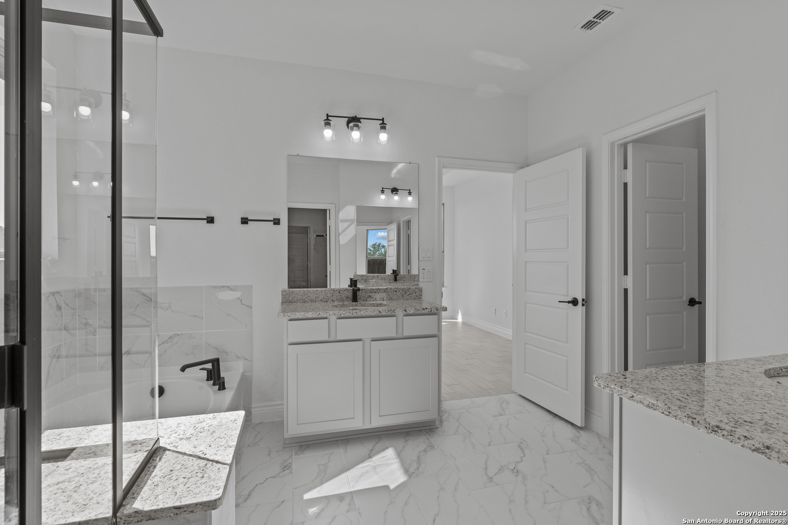 4044 Paddock Trail Seguin, TX 78155 - Photo 23 of 37 a bathroom with a granite countertop sink mirror and shower