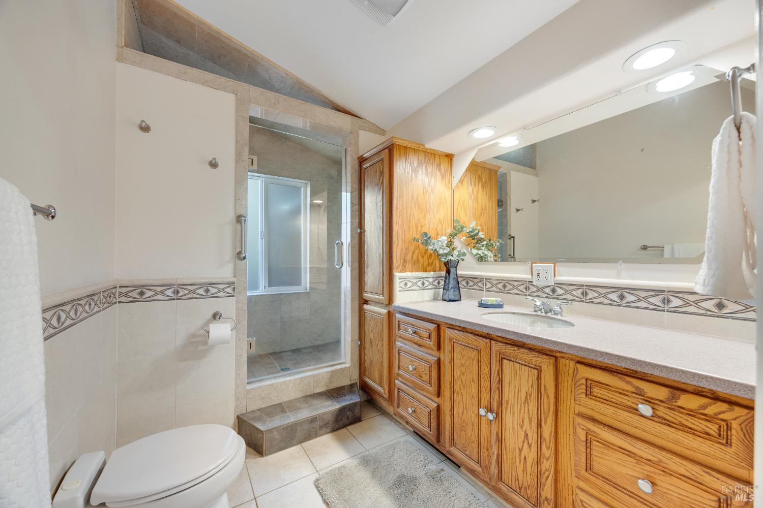 6960 Round Oak Road Penngrove, CA 94951 - Photo 33 of 58 a spacious bathroom with a granite countertop sink toilet a mirror and shower