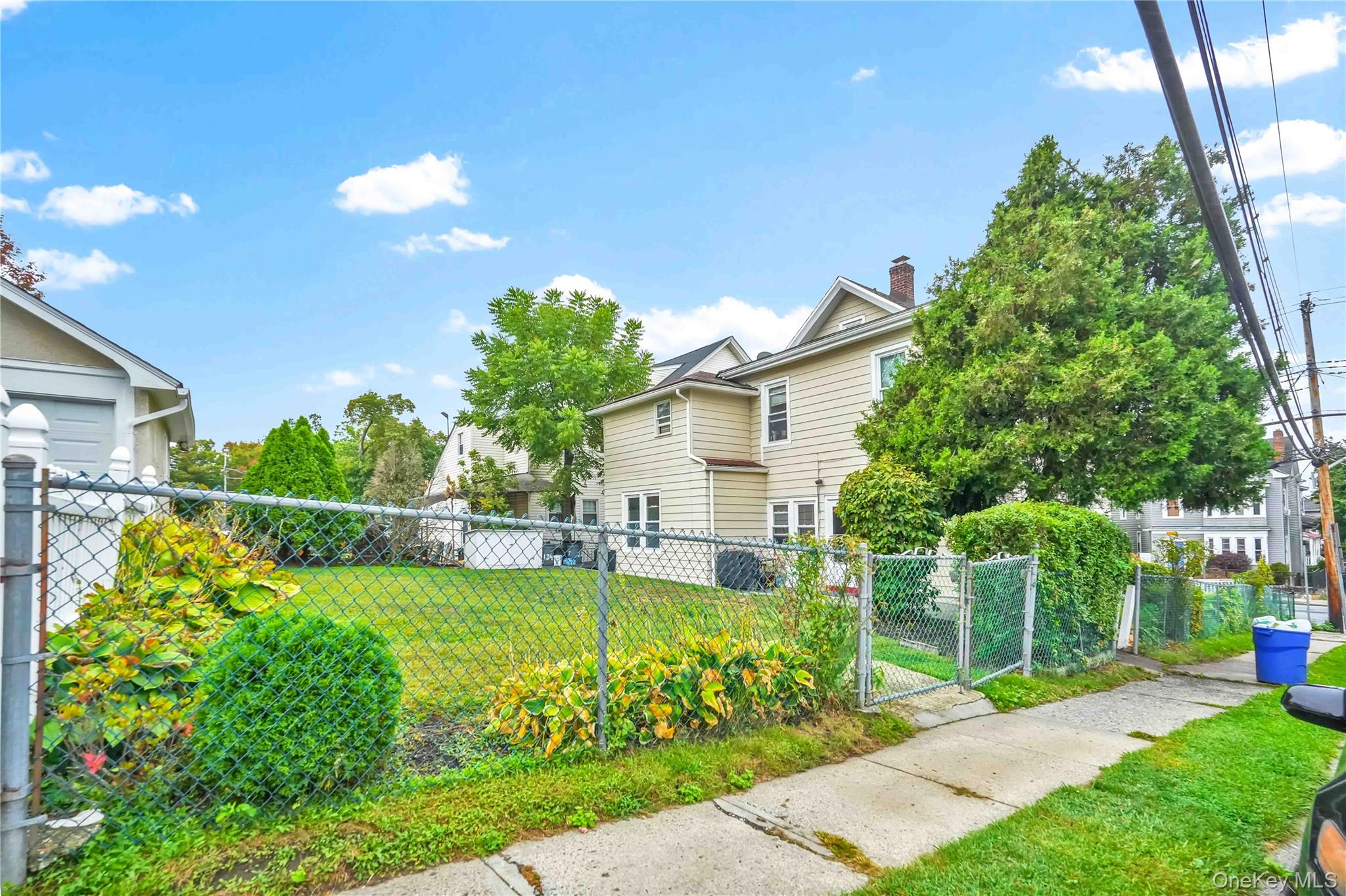 139 Spring Street Ossining, NY 10562 - Photo 26 of 29 View of side of home with a gate, a fenced front yard, and a chimney