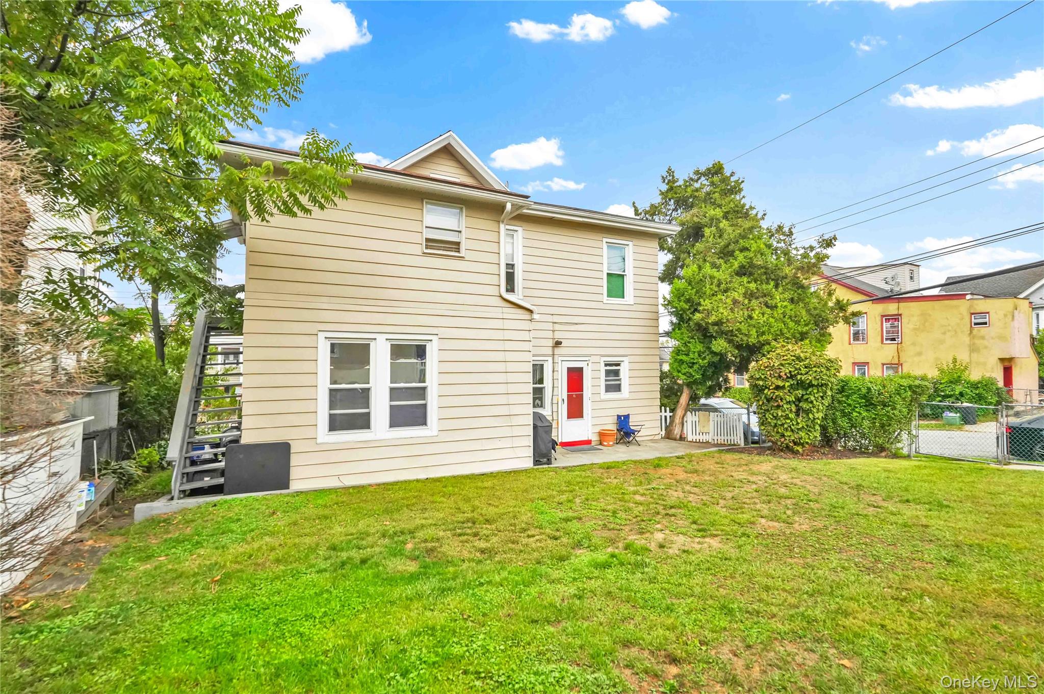 139 Spring Street Ossining, NY 10562 - Photo 28 of 29 Back of property with stairs, a fenced backyard, a patio, and a gate