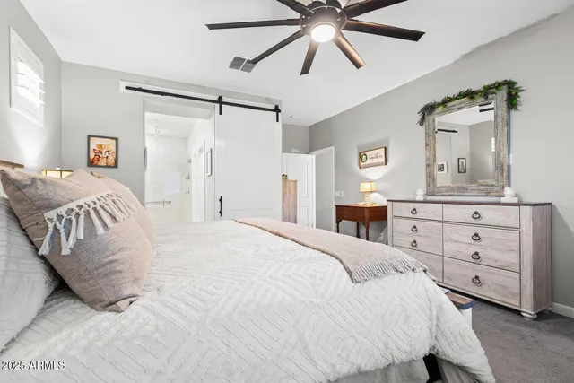 a bedroom with a bed and a mirror on the dresser