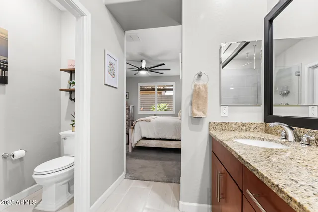 a en suite bathroom with a granite countertop sink and a mirror