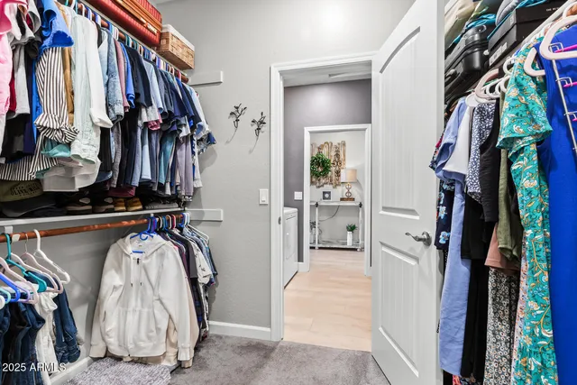 a view of walk in closet with clothes and shoes
