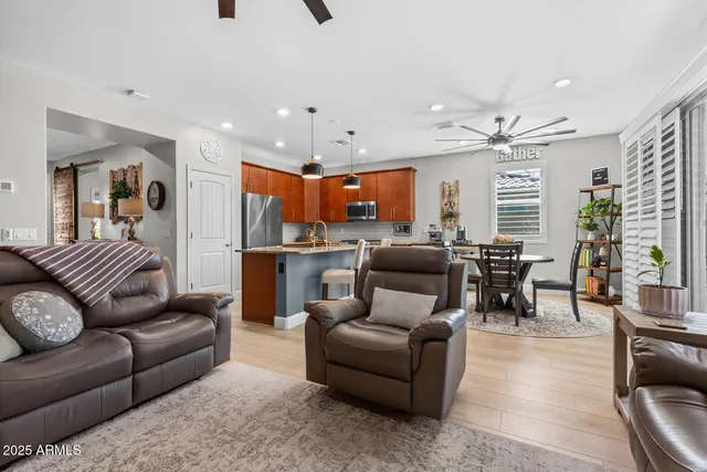 a living room with furniture kitchen view and a chandelier