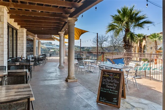 a patio with table and chairs and potted plants