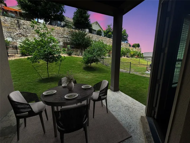 a view of a chairs and table in patio with a yard