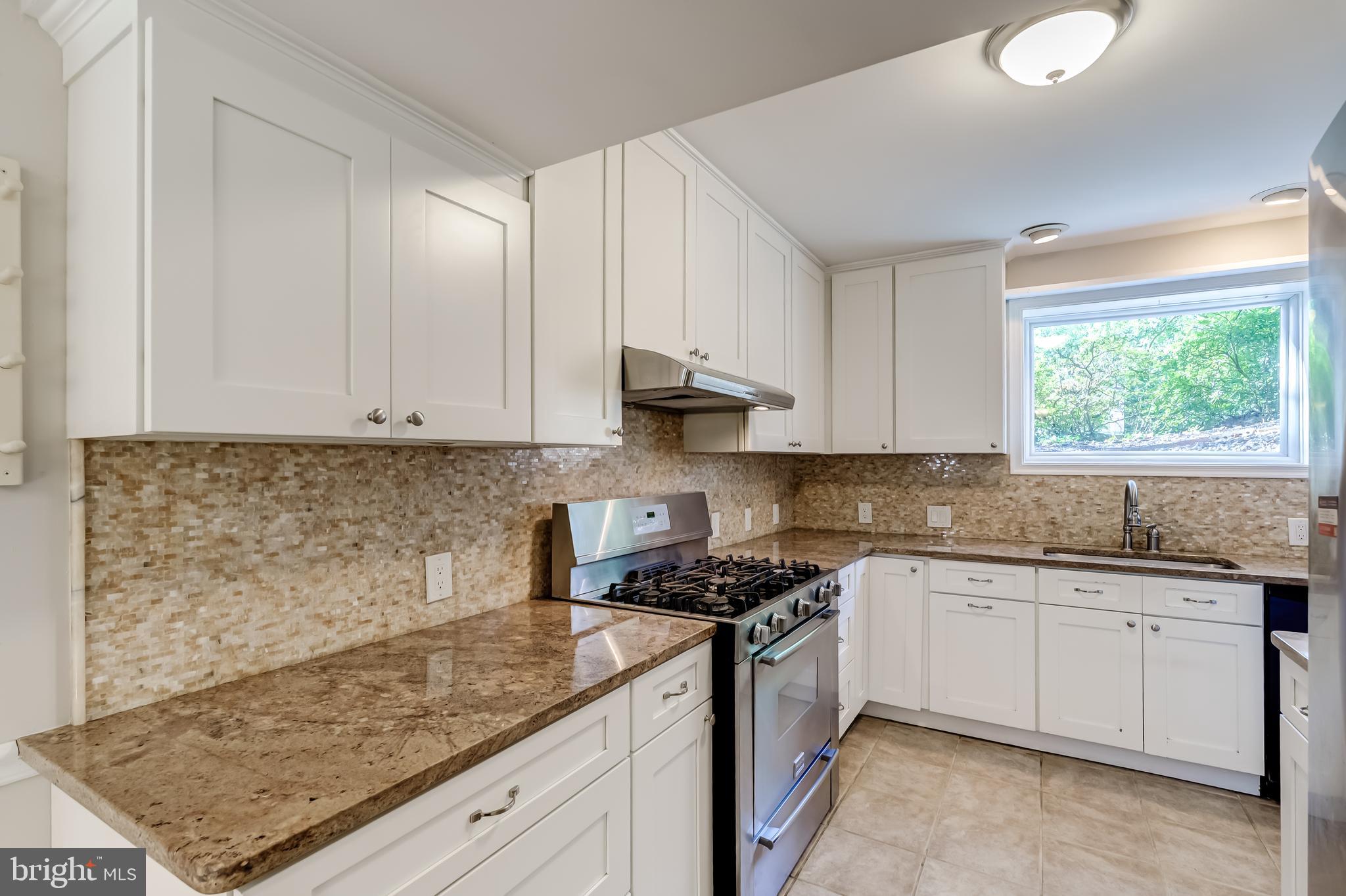 8817 Gateshead Road Alexandria, VA 22309 - Photo 17 of 78 a kitchen with granite countertop a sink a stove and cabinets