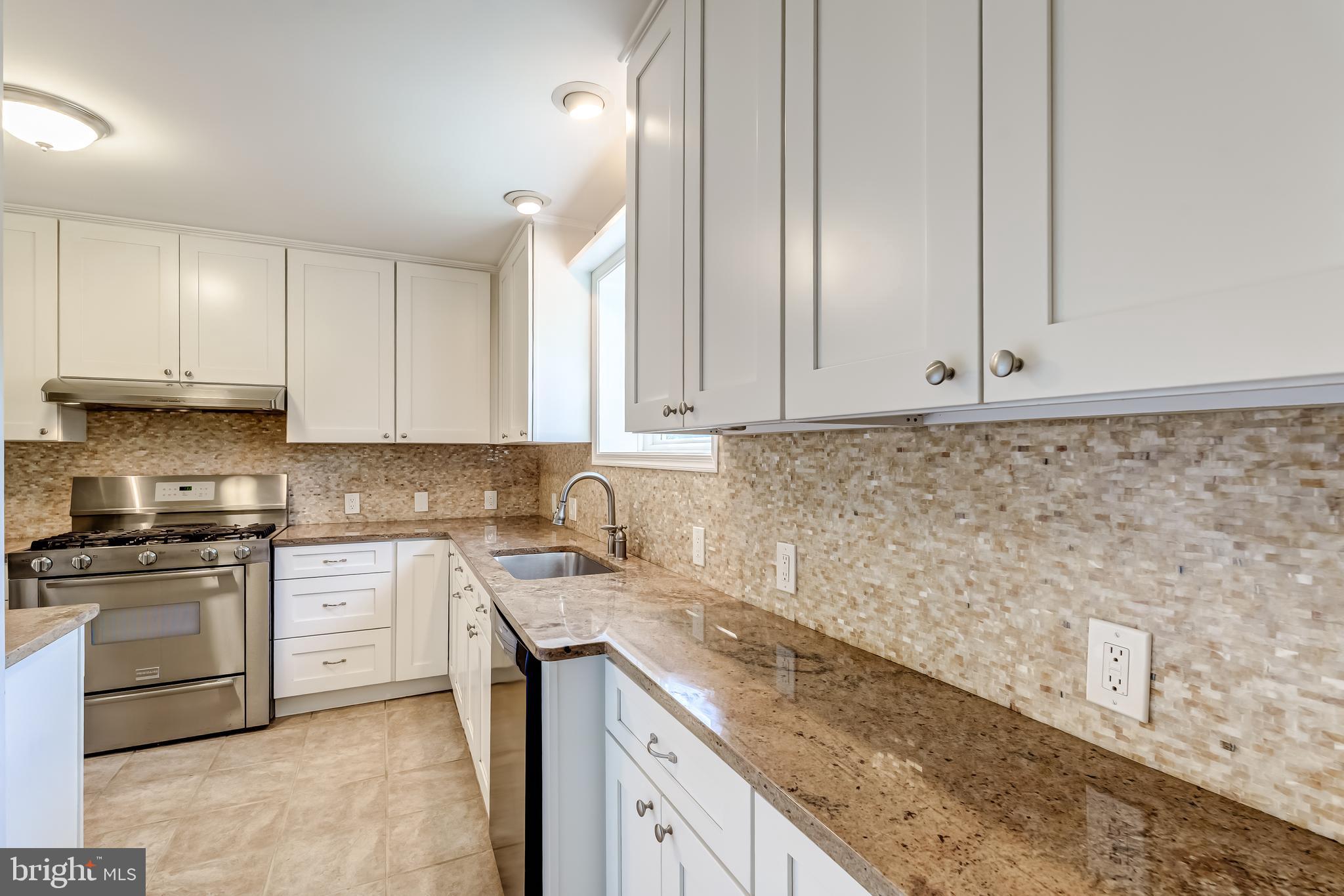 8817 Gateshead Road Alexandria, VA 22309 - Photo 18 of 78 a kitchen with granite countertop white cabinets and stainless steel appliances