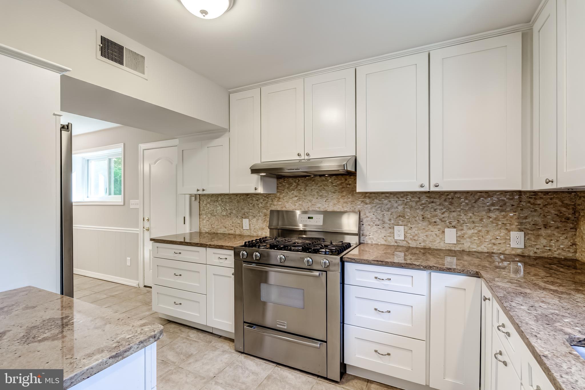8817 Gateshead Road Alexandria, VA 22309 - Photo 19 of 78 a kitchen with granite countertop white cabinets and white appliances