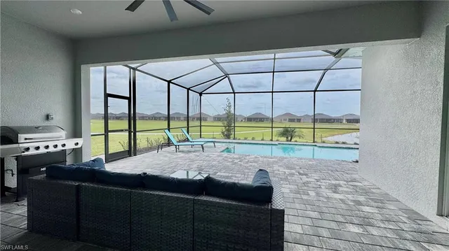 a living room with a bed and a dresser next to a window