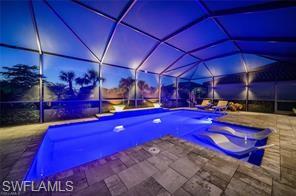 17574 Ashcomb Way Estero, FL 33928 - Photo 17 of 29 a view of a pool with a table and chairs under an umbrella