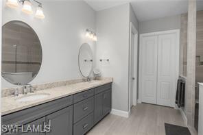 17574 Ashcomb Way Estero, FL 33928 - Photo 20 of 29 a bathroom with a double vanity sink and mirror
