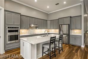 17574 Ashcomb Way Estero, FL 33928 - Photo 6 of 29 a kitchen with a table chairs refrigerator and microwave