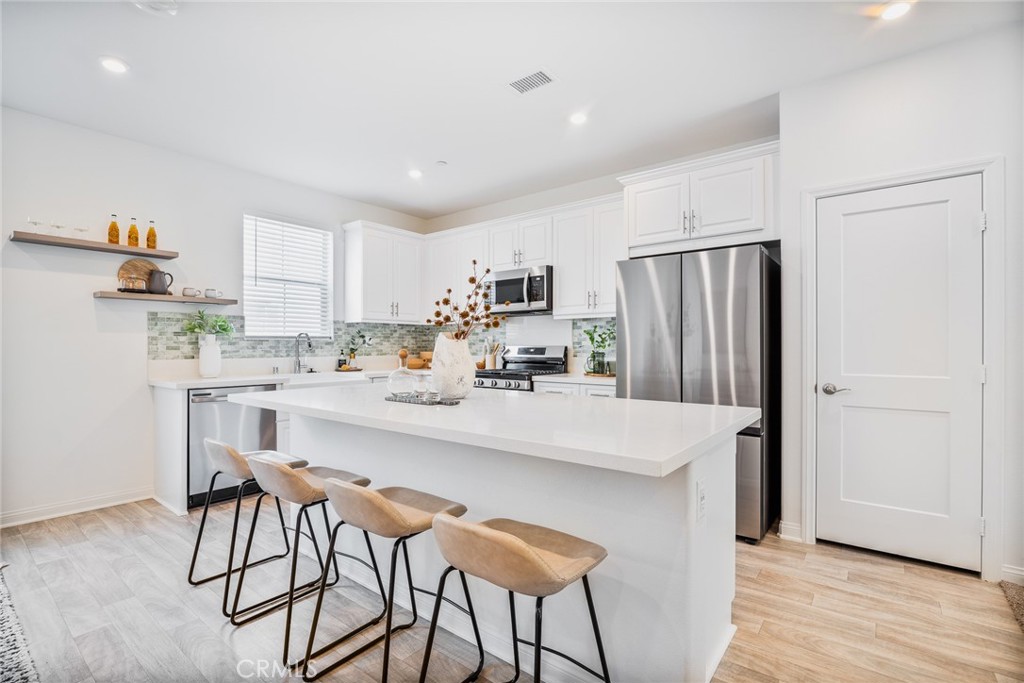 a kitchen with stainless steel appliances a refrigerator and a stove top oven