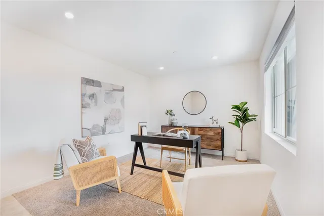 a living room with furniture a window and a potted plant